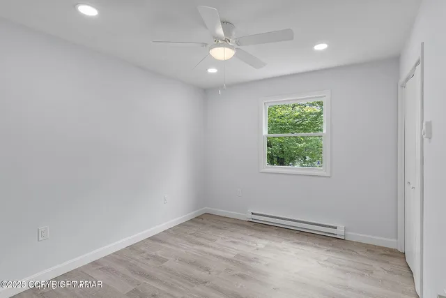 an empty room with a window and a fan