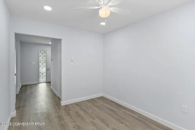 a view of an empty room with wooden floor