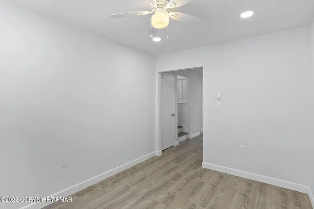 a view of an empty room with a chandelier fan