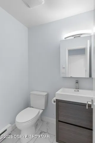 a bathroom with a toilet sink and mirror