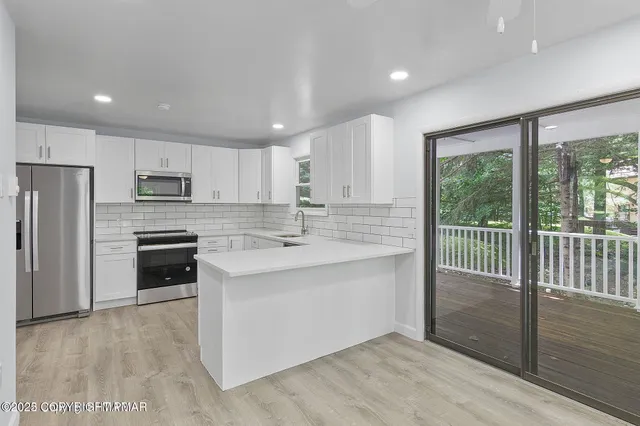 a kitchen with stainless steel appliances granite countertop a stove a sink and a refrigerator