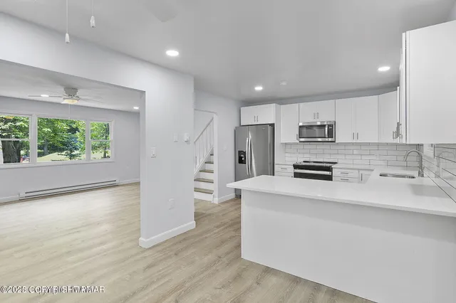 a kitchen with stainless steel appliances a refrigerator and a stove top oven