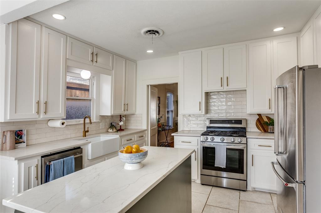 4601 Pershing Avenue Fort Worth, TX 76107 - Photo 8 of 28 a kitchen with stainless steel appliances a stove refrigerator sink and cabinets