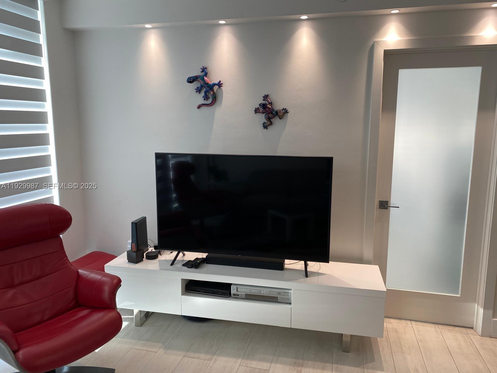 5601 Collins Avenue, Unit 622 Miami Beach, FL 33140 - Photo 6 of 15 a living room with furniture and a flat screen tv