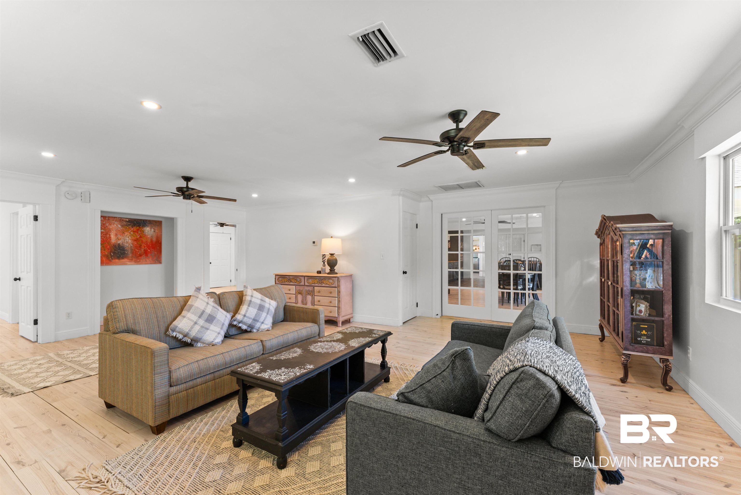 6447 Bemis Lane Bon Secour, AL 36511 - Photo 21 of 62 Spacious living area featuring light wood-finish flooring, white walls, and crown molding