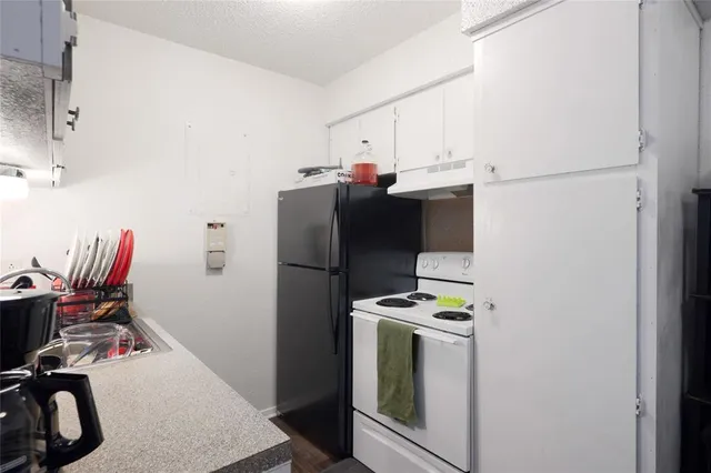 a view of kitchen with refrigerator stove and sink