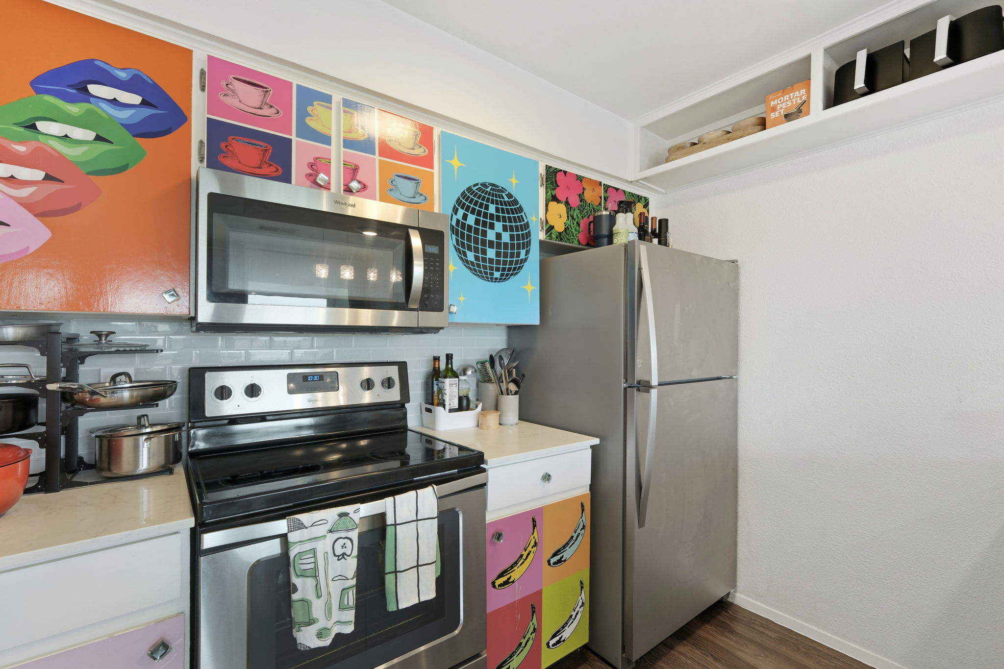 6910 Hart Lane, Unit 912 Austin, TX 78731 - Photo 11 of 36 Kitchen featuring stainless steel appliances, including an over-range microwave, electric range, and refrigerator