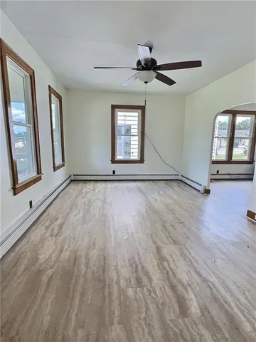 a view of an empty room and window with wooden floor