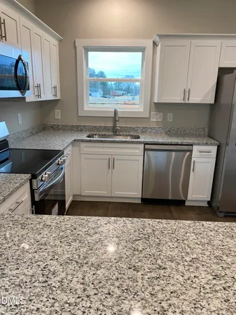 a kitchen with a sink a stove and cabinets