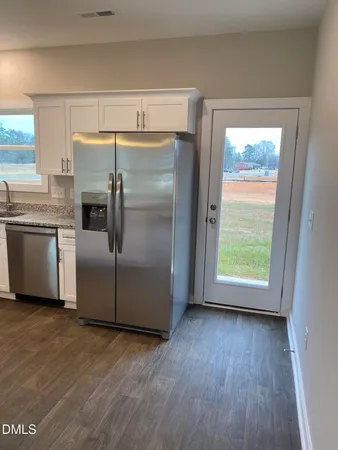 a kitchen with granite countertop stainless steel appliances a counter top space and a large window