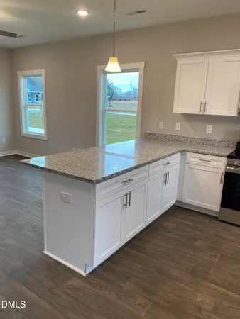 a kitchen with granite countertop white cabinets and white appliances