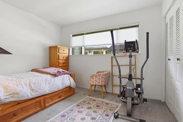 a bedroom with a bed a window and chair