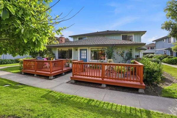 a view of a house with a wooden deck and a yard
