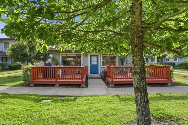 a view of a house with a deck and a yard