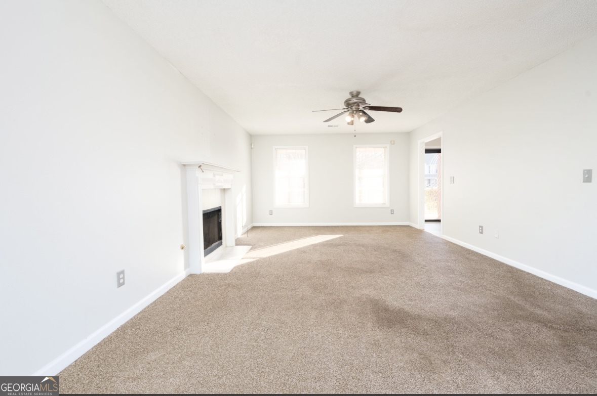 4414 Mitchells Ridge Drive Ellenwood, GA 30294 - Photo 6 of 25 an empty room with a fireplace and windows