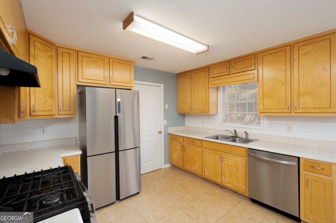 4414 Mitchells Ridge Drive Ellenwood, GA 30294 - Photo 9 of 25 a kitchen with stainless steel appliances granite countertop a refrigerator and a sink