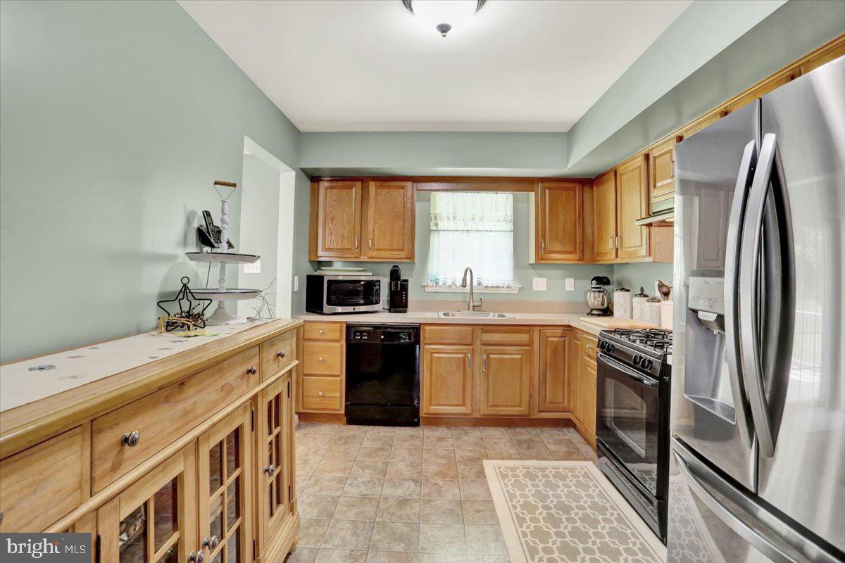 1017 Saylor Drive Temple, PA 19560 - Photo 11 of 36 a kitchen with granite countertop a refrigerator stove top oven and sink