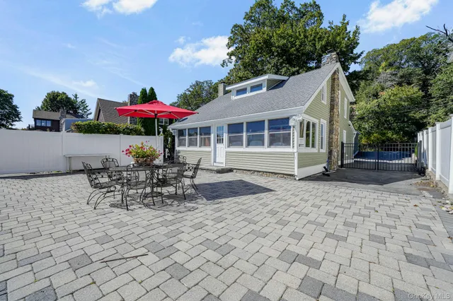 a view of a patio with table and chairs with wooden fence and plants