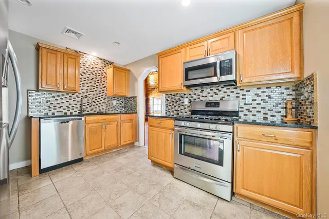 a kitchen with stainless steel appliances granite countertop a stove and a microwave