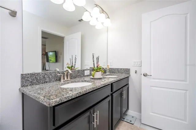 a bathroom with a granite countertop sink toilet mirror and shower