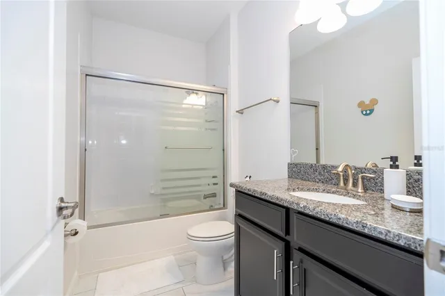 a bedroom with a bed and a view of kitchen