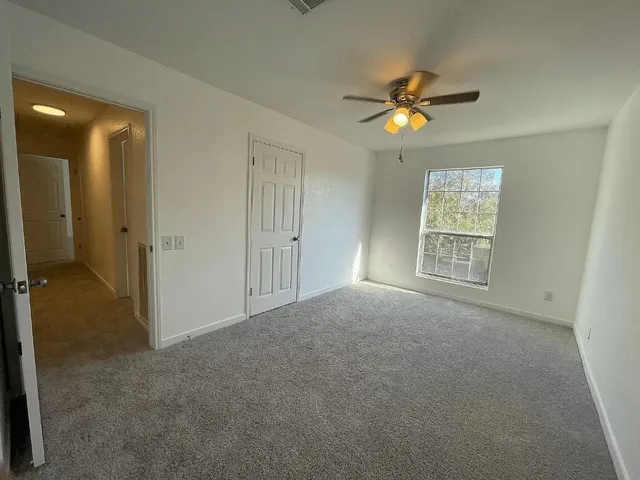 a view of an empty room with a fireplace and a window
