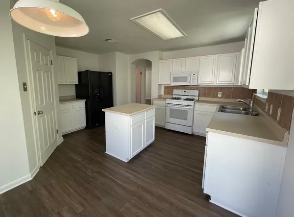 a kitchen with a sink a refrigerator a stove and cabinets