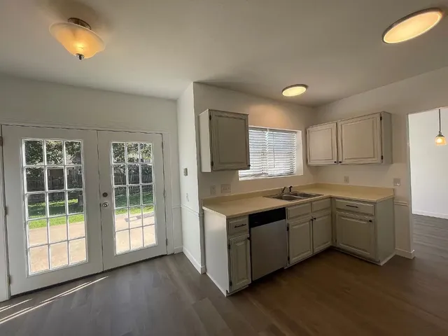 a room with stainless steel appliances granite countertop a stove and a sink