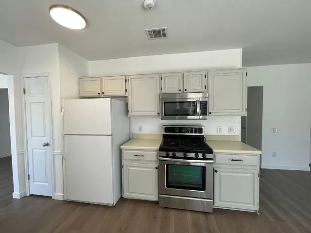 a kitchen with a white stove and white cabinets
