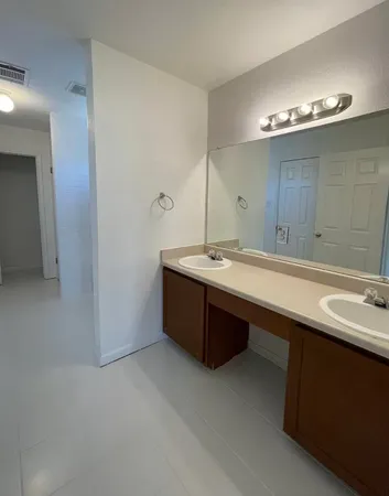 a bathroom with a double vanity sink and a mirror