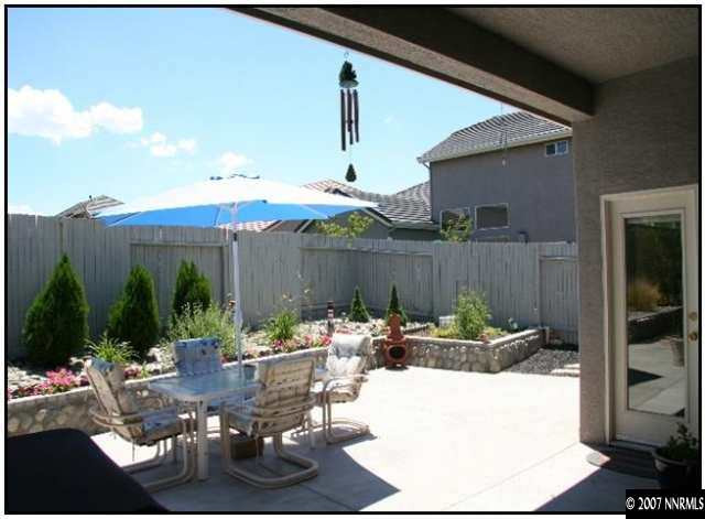 10490 Gold Arrow Drive Reno, NV 89521 - Photo 8 of 9 a view of a patio with couches and table and chairs under an umbrella