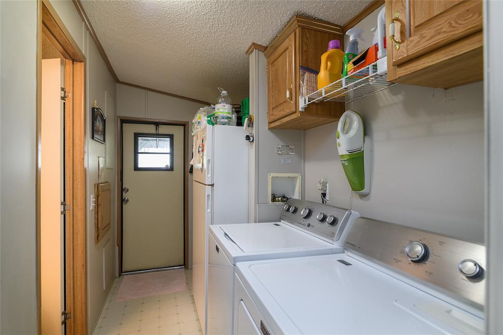 122 Grice Road Ringgold, LA 71068 - Photo 19 of 26 Dedicated laundry area featuring a washer and dryer with overhead cabinetry and a wire shelf for storage