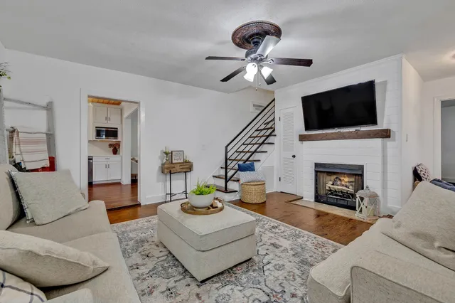 a living room with furniture a flat screen tv and a fireplace