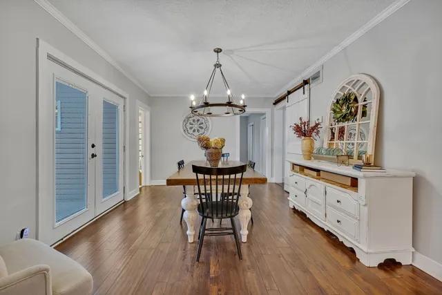 a dining room with furniture a chandelier and wooden floor
