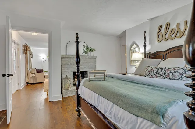 a bedroom with a large bed and a wooden floor