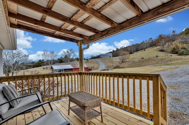 a view of a patio with table and chairs with wooden floor and fence