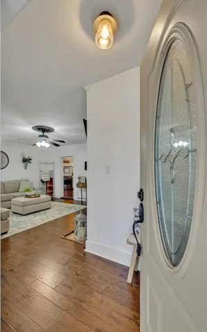 a view of a livingroom with furniture wooden floor and a mirror