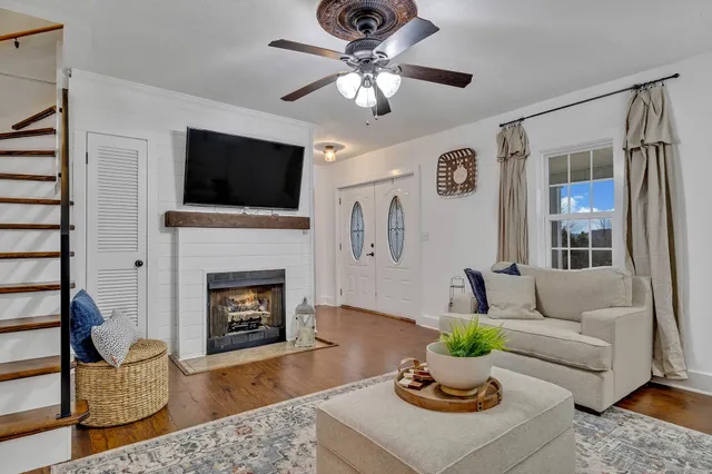 a living room with furniture a flat screen tv and a fireplace
