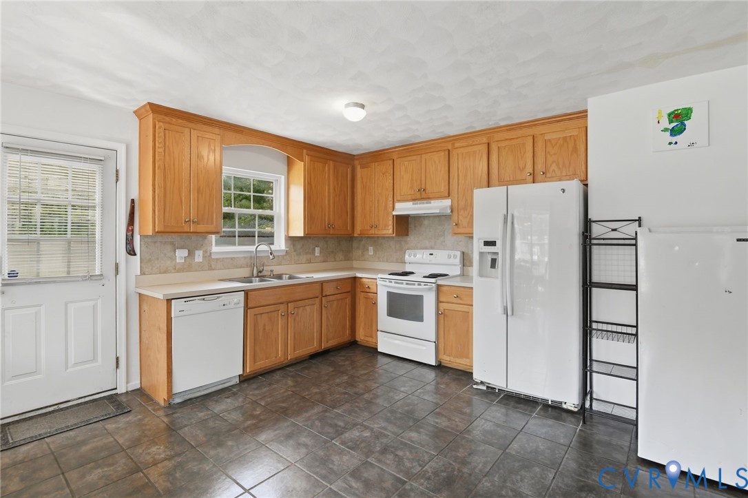 117 Pleasant Spring Avenue Waverly, VA 23890 - Photo 9 of 17 a kitchen with a refrigerator and window