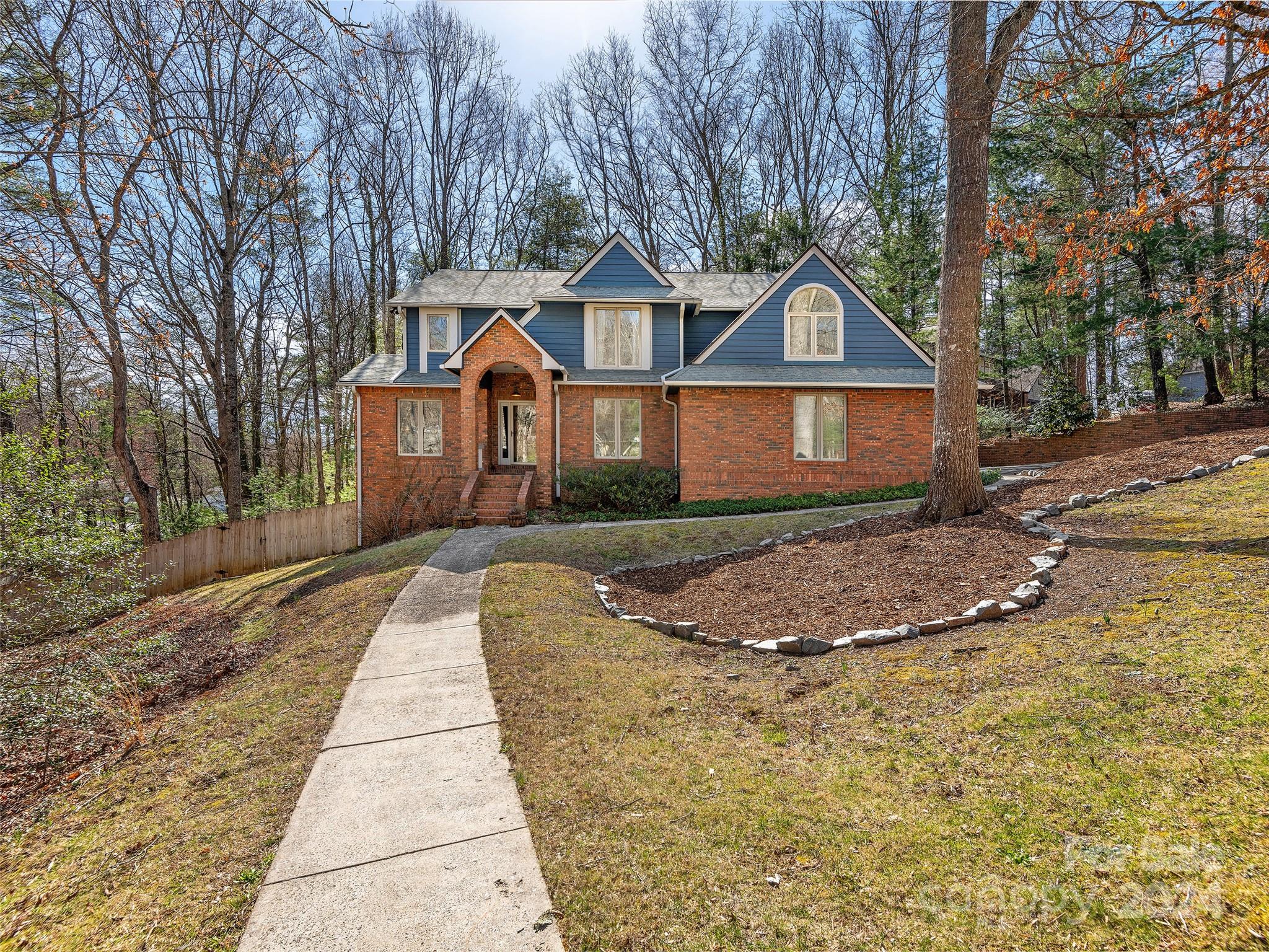 a front view of a house with a yard and trees