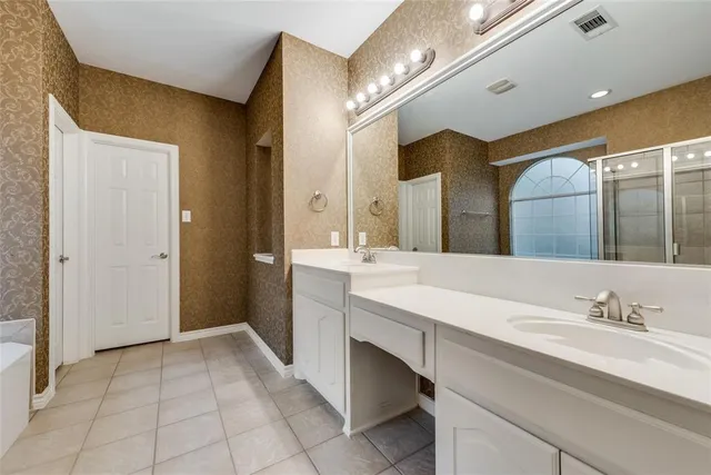 a spacious bathroom with a double vanity sink and a mirror