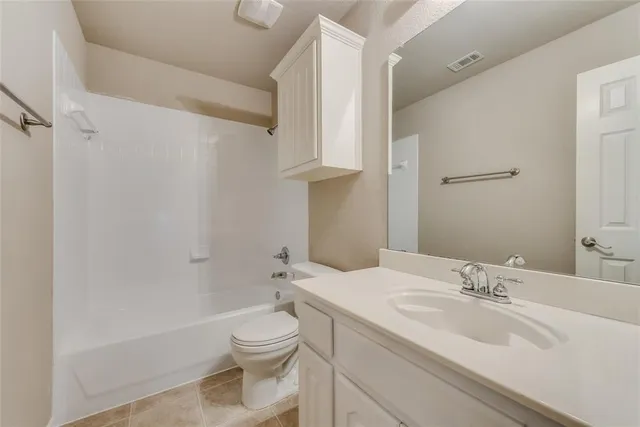 a bathroom with a granite countertop sink a toilet and shower
