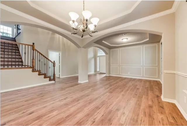 a view of a livingroom with wooden floor and stairs