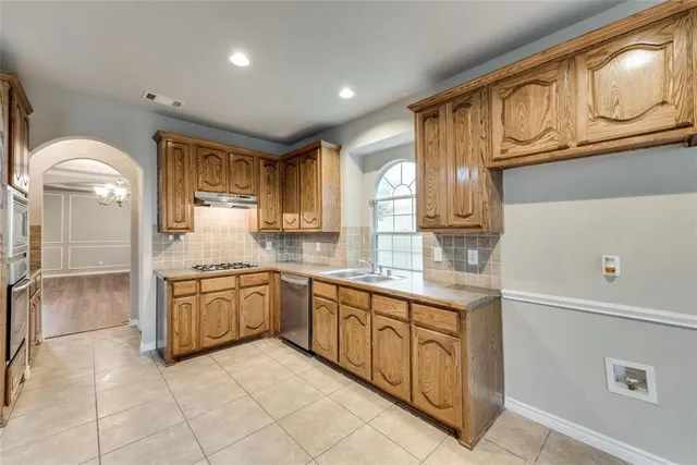 a kitchen with stainless steel appliances granite countertop a refrigerator and a stove top oven