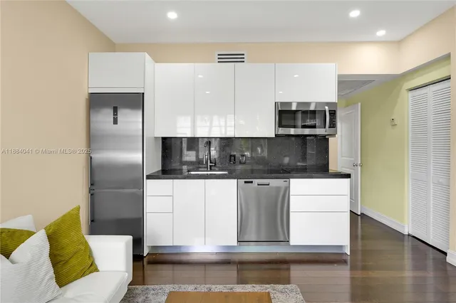 a kitchen with stainless steel appliances kitchen island granite countertop a refrigerator and a stove top oven