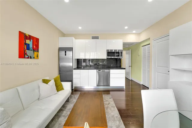 a large living room with stainless steel appliances furniture