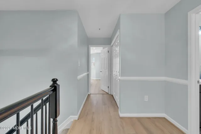 a view of a hallway with wooden floor and closet