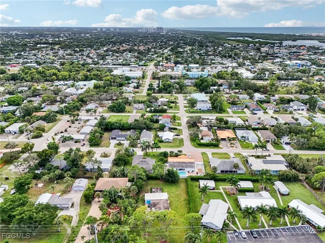 an aerial view of residential houses with outdoor space and trees