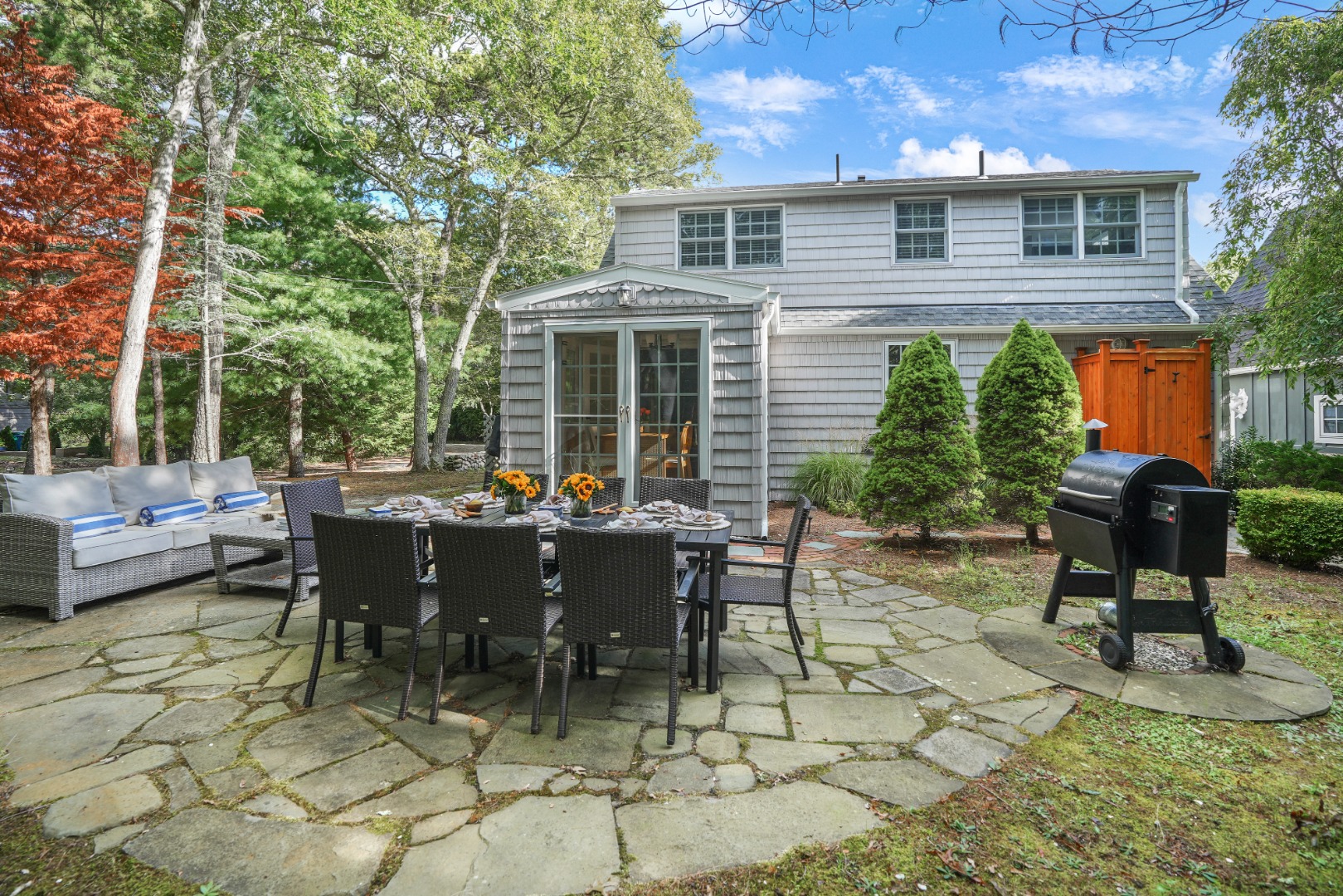 26 Sea Glen Road Oak Bluffs, MA 02557 - Photo 34 of 36 a view of a patio with table and chairs with wooden fence and plants