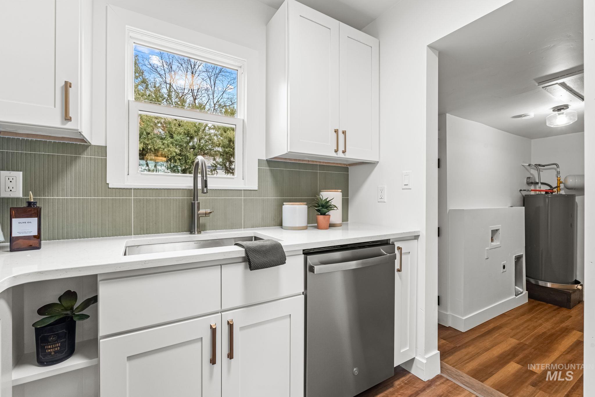 5420 Anna Street Boise, ID 83705 - Photo 13 of 24 Kitchen featuring white cabinets, stainless steel dishwasher, dark wood finished floors, and tasteful backsplash